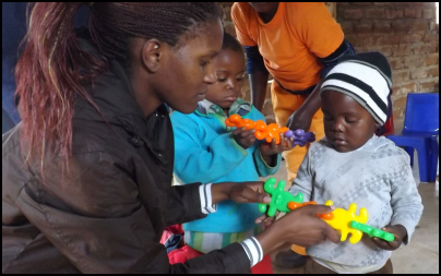 Mission Aviation Fellowship volunteer Chimwemwe Calawe shows children how to use educational toys.
