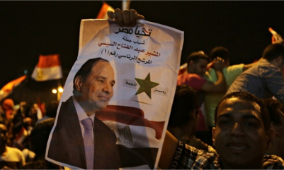 A supporter holds up a poster of Egypt's former army chief Abdel Fatah al-Sisi as he celebrates in Tahrir Square in Cairo. Photograph: Amr Abdallah Dalsh/Reuters