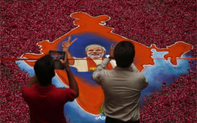 Indians take photographs of a portrait of Bharatiya Janata Party (BJP) leader Narendra Modi, made with colored powder and surrounded by rose petals, at the party office in Gandhinagar, in the western Indian state of Gujarat, Friday, May 16, 2014. Modi will be India's next prime minister, winning the most decisive election victory the country has seen in more than a quarter century and sweeping the long-dominant Congress party from power, partial results showed Friday. (PHOTO: AP /Saurabh Das)