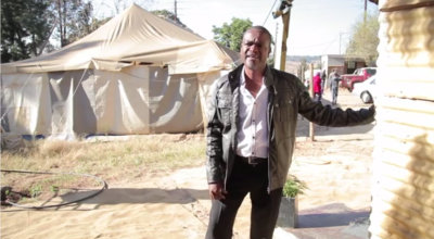 Pastor Sipho in front of the old tent which has been serving as church and community centre for nearly 20 years.