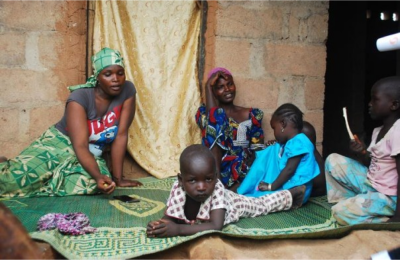 A woman talks about her escape from violence after Boko Haram insurgents attacked her community weeks ago, while sitting near others at the internally displaced persons (IDP) camp at Wurojuli, Gombe State September 2, 2014. REUTERS/Samuel Ini