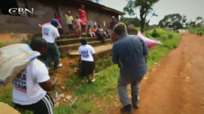 Christian volunteers take food to families in quarantine in their homes in a Liberian village because of Ebola.