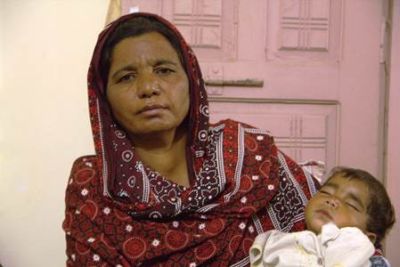 Parveen Bibi, sister of the murdered husband, holds the dead couple's baby - one of four children orphaned by the killing  4 Nov Punjab, Pakistan Asif Aqeel