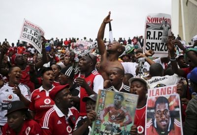 REUTERS/Siphiwe Sibeko Mourners sing as they hold posters with the picture of South African national soccer team goalkeeper and captain Senzo Meyiwa during his funeral service in Durban November 1, 2014