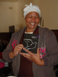 A happy lady with her first ever Bible which was given to her during the Bag Angels' first shelter visit.