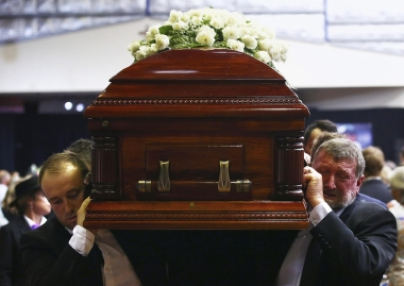 Gregory (R) and Jason Hughes, the father and brother respectively of Australian cricketer Phillip Hughes, carry his casket past mourners after his funeral service, on December 3, 2014.(PHOTO: Reuters).
