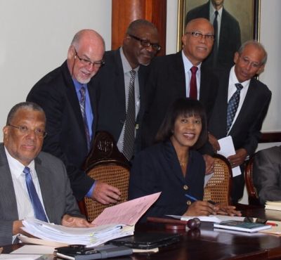 Jamaican Prime Minister Honourable Mrs Portia Simpson-Miller, signs the Unashamedly Ethical (UE) pledge form. UE founder, Graham Power (second from left) looks on together with Jamaican leaders.