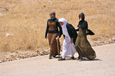 Displaced families from the minority Yazidi sect, fleeing the violence, walk on the outskirts of Sinjar, west of Mosul.